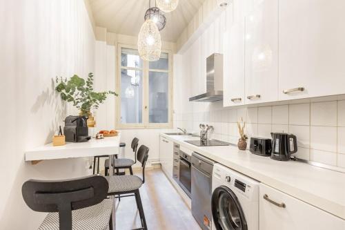 une cuisine blanche avec un lave-linge et un sèche-linge. dans l'établissement Amazing Apartment 3Bedrooms Champs Elysées#AC, à Paris