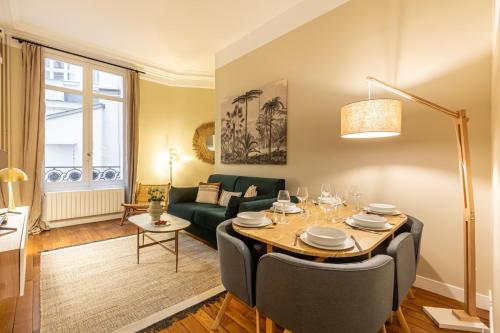 un salon avec une table et un canapé dans l'établissement Amazing Apartment 3Bedrooms Champs Elysées#AC, à Paris