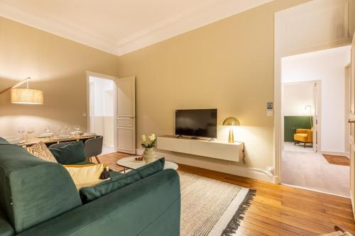 un salon avec un canapé et une télévision dans l'établissement Amazing Apartment 3Bedrooms Champs Elysées#AC, à Paris