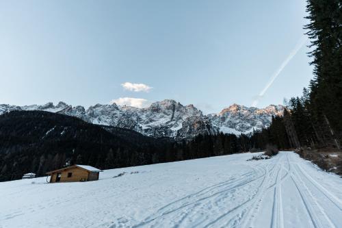 a snow covered mountain with a house in the distance at le Gemme - Dolomites escape in Dosoledo
