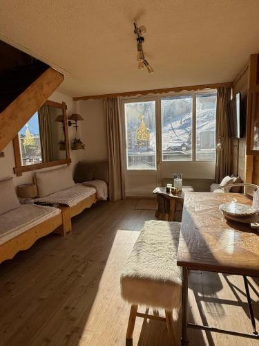 un salon avec une grande fenêtre et un canapé dans l'établissement Superbe duplex rare à la location, à Pra-Loup