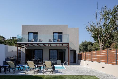 a glass house with a patio and tables and chairs at Villa Fotinou Heated Pool & Free Bikes awaits in Fotinós
