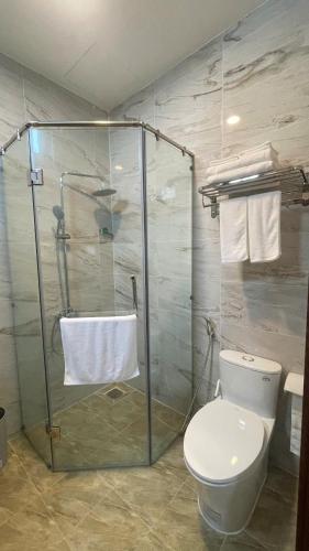 a bathroom with a toilet and a glass shower at Hotel ĐÁ ĐỎ in Da Nang