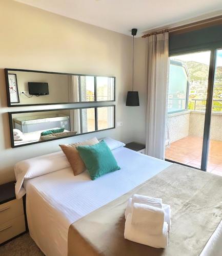 a bedroom with a large bed with a large mirror at Apartamentos Nuriasol in Fuengirola