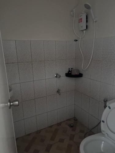 a bathroom with a toilet and a phone on the wall at Baden Powell Hostel in Baguio