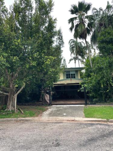 a house with a fence and a palm tree at Studio Classic Tropical Darwin in Jingili