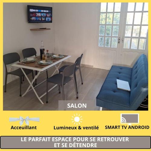 a dining room with a table and a blue chair at Chambre Carnaval Abymes Guadeloupe in Les Abymes