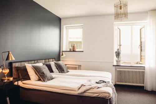 a bedroom with a large bed with a black wall at Varbergs Kusthotell in Varberg