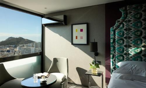 a hotel room with a bed and a table and a window at President Hotel Athens in Athens