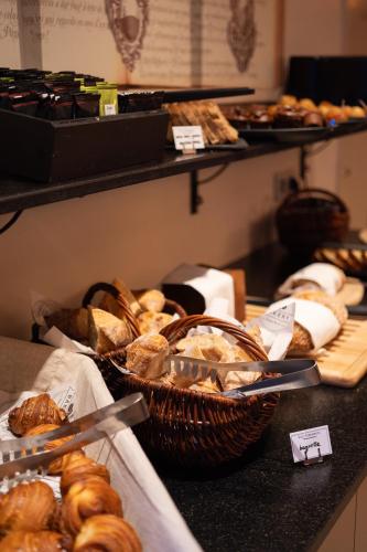 una mesa con cestas de pan y bollería en La Maison des Armateurs, en Saint-Malo