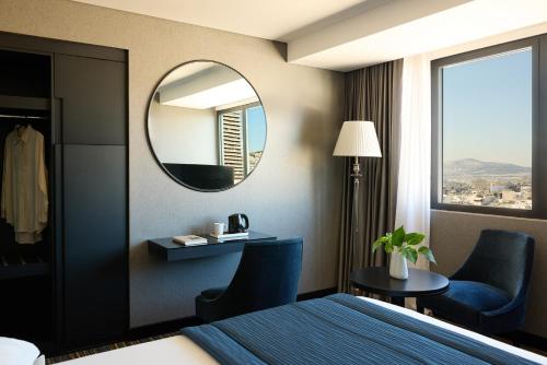 a hotel room with a bed and a mirror at President Hotel Athens in Athens