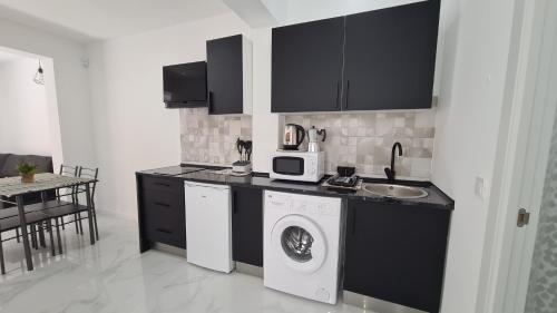 a kitchen with a washing machine and a microwave at Apartamento Centro Benidorm 1 IF Benidorm in Benidorm