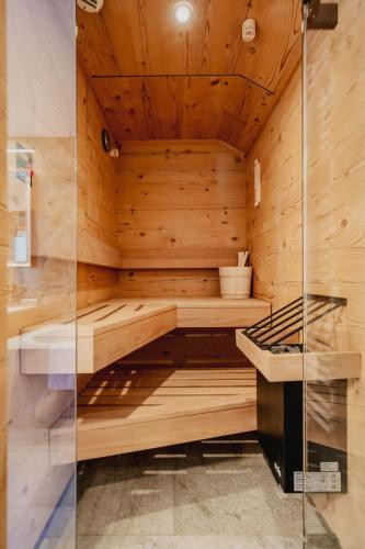a sauna with wooden walls and a glass door at Alpenromantik-Hotel Wirlerhof in Galtür