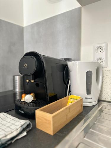 - une cafetière installée au-dessus d'un comptoir de cuisine dans l'établissement Studio1 rue Théodore Bac - DABNB, à Limoges