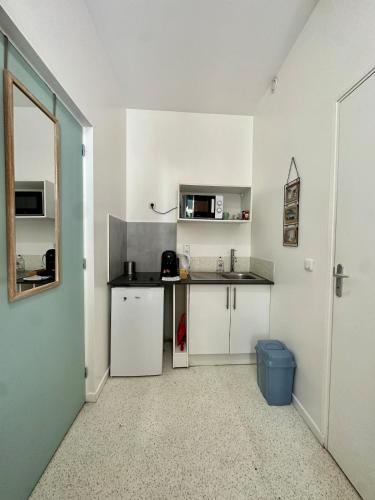 une cuisine avec des armoires blanches et un comptoir dans l'établissement Studio1 rue Théodore Bac - DABNB, à Limoges