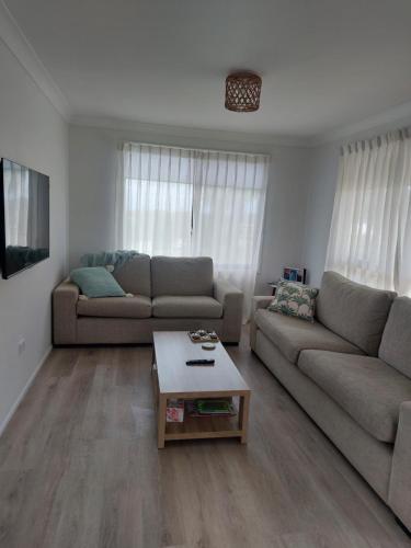 a living room with two couches and a coffee table at Stay Breezy in Erowal Bay