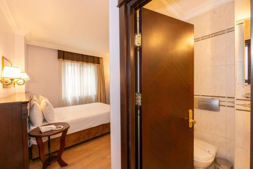a bathroom with a bedroom with a bed and a toilet at Taksim Pera Rose Hotel & Spa - Istiklal Street in Istanbul