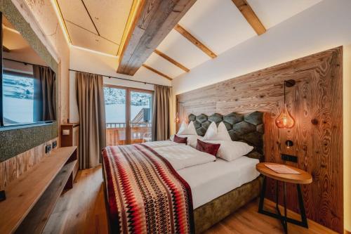 a hotel room with a bed and a window at Alpenromantik-Hotel Wirlerhof in Galtür