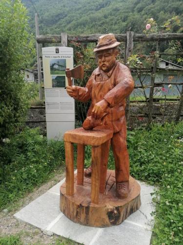 a statue of a man sitting on a stool at CasAdelinA in Arnaz