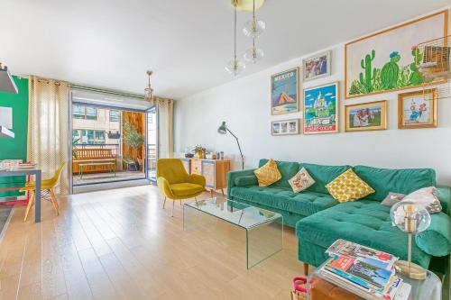 a living room with a green couch and a table at La Casita Mexicana - Kids Friendly by So Homy- 3 Bed Room - 6 PAX in Saint-Ouen