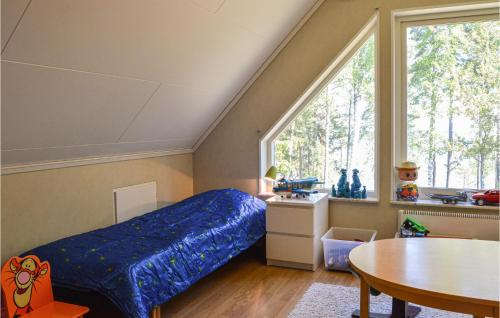 a bedroom with a bed and a table and a window at 4 Bedroom Lovely Home In Mariefred in Mariefred