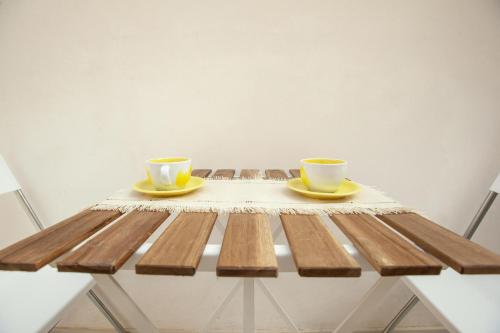 a wooden table with two coffee cups on it at Casa Ancora Fronte Mare in San Leone