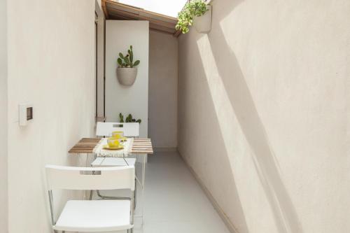a small balcony with a table and white chairs at Casa Ancora Fronte Mare in San Leone