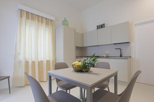 a dining room table with chairs and a bowl of fruit on it at Casa Ancora Fronte Mare in San Leone