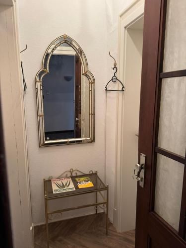 a mirror on a wall next to a table at Fewo & Monteurzimmer Forbrich in Eislingen