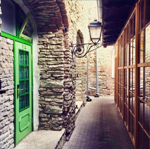an alley with a green door in a stone building at St.Olav Hotel in Tallinn