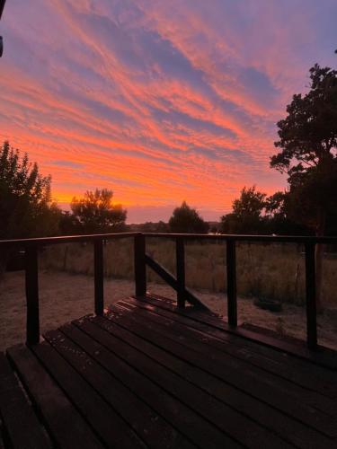 a wooden bench with a sunset in the background at Cabaña Arrebol Costero in Ancud