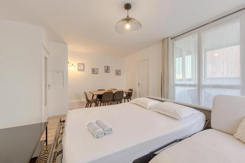 トルシーにあるDisney apartment for 6 peopleの白いベッドルーム(ベッド1台、テーブル付)