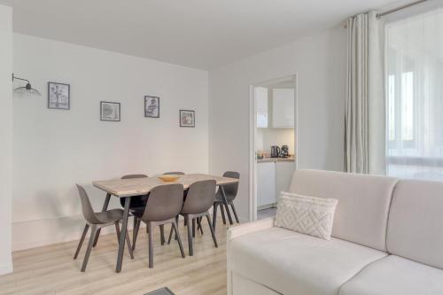 un salon avec une table, des chaises et un canapé dans l'établissement Disney apartment for 6 people, à Torcy