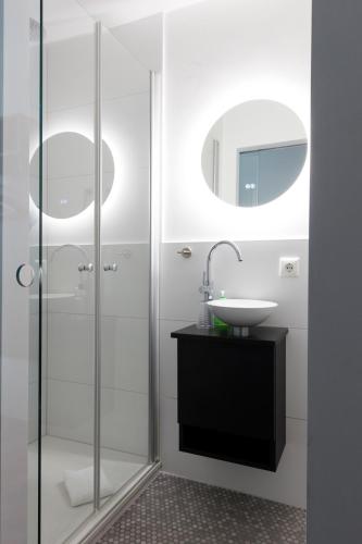 a bathroom with a sink and a shower at Altstadthotel Wetzel in Mühldorf