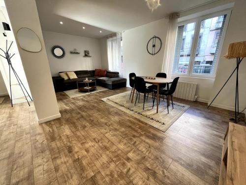 un salon avec une table, des chaises et un canapé dans l'établissement L 'Épicentre, à Clermont-Ferrand