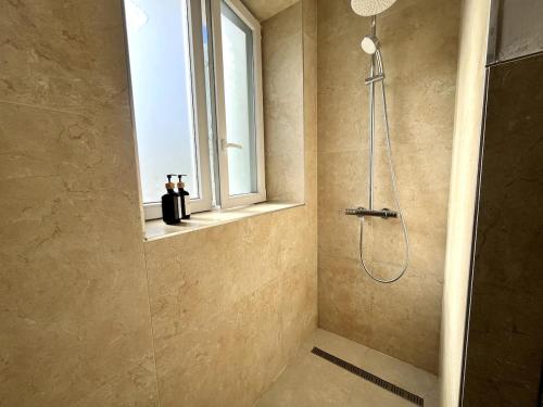 une salle de bain avec douche et fenêtre dans l'établissement L 'Épicentre, à Clermont-Ferrand