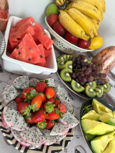 a table topped with plates of fruits and vegetables at Casa Pérolas do Mar in Balneário Camboriú