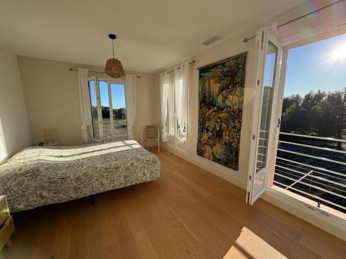 a bedroom with a bed and a large window at Mas de l'Archange in Montagnac