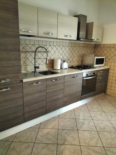 a kitchen with wooden cabinets and a sink at La casa di Beba in Collescipoli