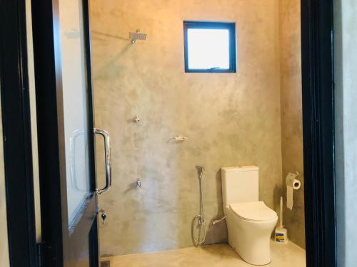 ein Bad mit einem WC und einer Dusche mit einem Fenster in der Unterkunft Midigama Home Stay Villa Apartment in Weligama