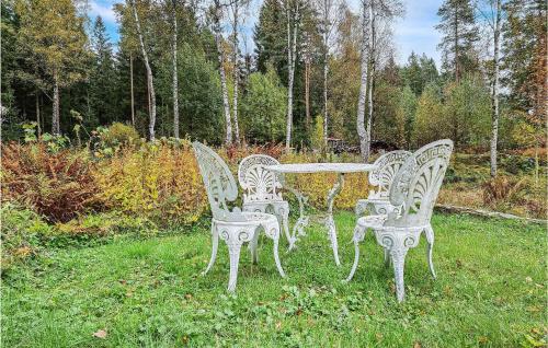 three white chairs and a table in the grass at Amazing Home In Olsfors With Kitchen in Olsfors