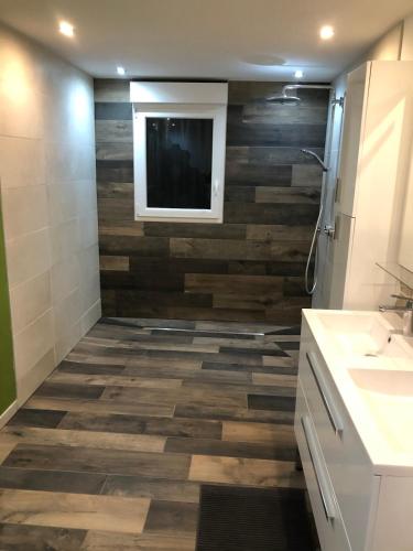 La salle de bains est pourvue d'un mur en bois. dans l'établissement La Ruine Single-family House with Hot Tub, à Laveline