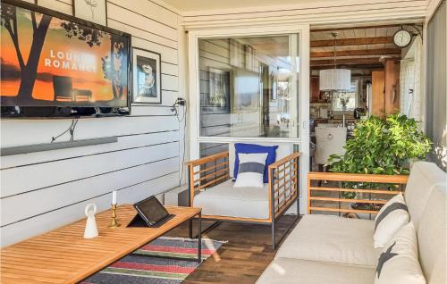 a screened in porch with a couch and a tv at Lovely Home In Uddevalla With Kitchen in Uddevalla