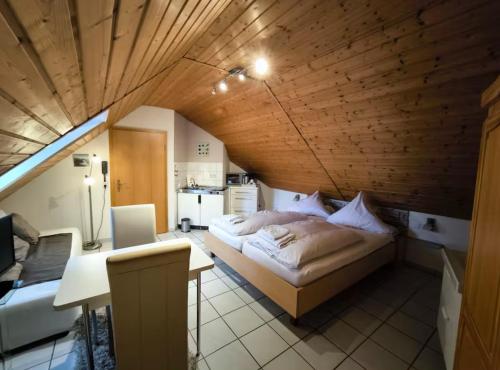 a bedroom with a bed and a table and a kitchen at Pension im Charme der 90er in Trier