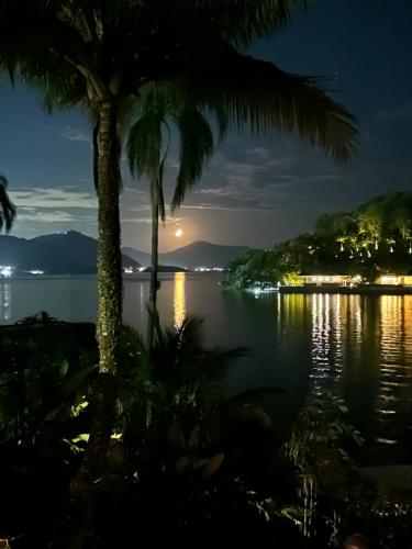 a view of a lake at night with palm trees at Cabana do Mar in Angra dos Reis