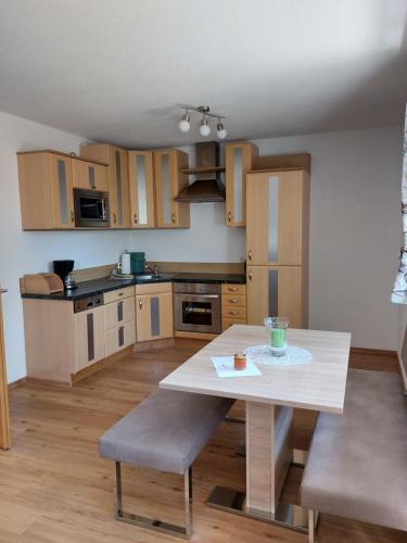 a kitchen with a table and chairs in a room at Ferienwohnung Gstreinthaler in Tulfes