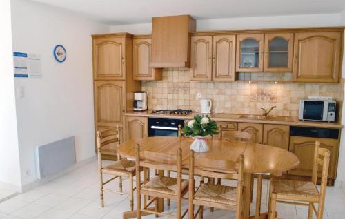 une cuisine avec des armoires en bois et une table en bois dans l'établissement Gorgeous Home In Carnac With Kitchen, à Carnac