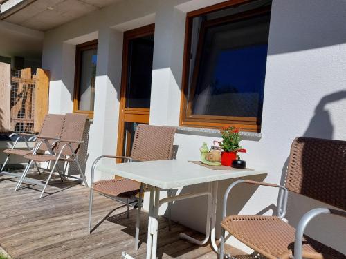 a white table and chairs on a porch with a window at Ferienwohnung Gstreinthaler in Tulfes
