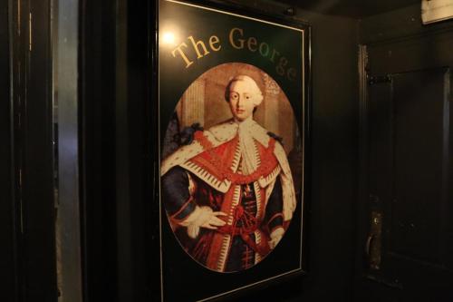 a picture of a portrait of a man on a wall at The George Hotel in Kirton in Lindsey