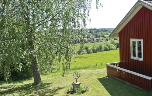 a red house with a tree next to a building at Awesome Home In Munkedal With Wifi in Munkedal